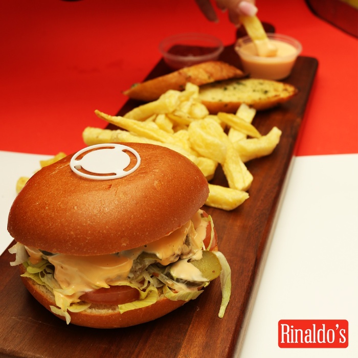 Rinaldo’s burger with chips, garlic bread slices and sauces. 